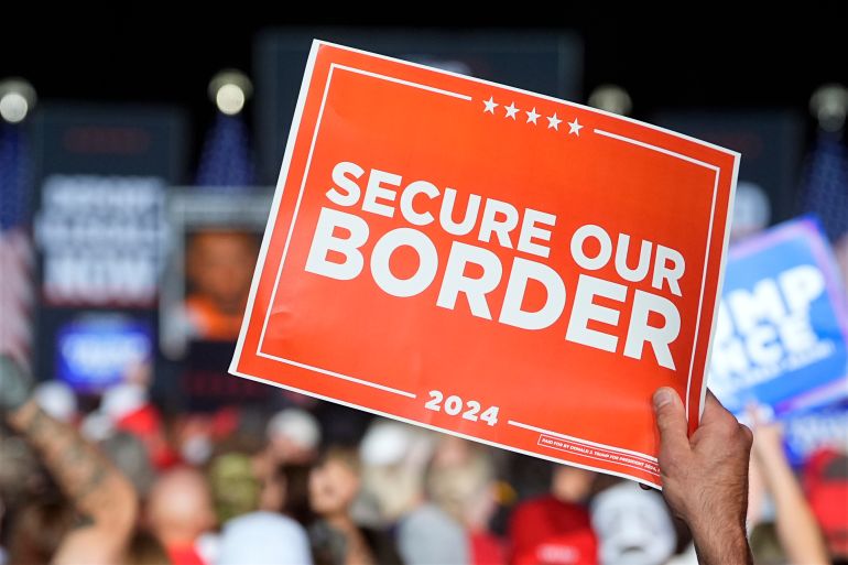 A Trump supporter holds up a sign that reads, "Secure Our Border."