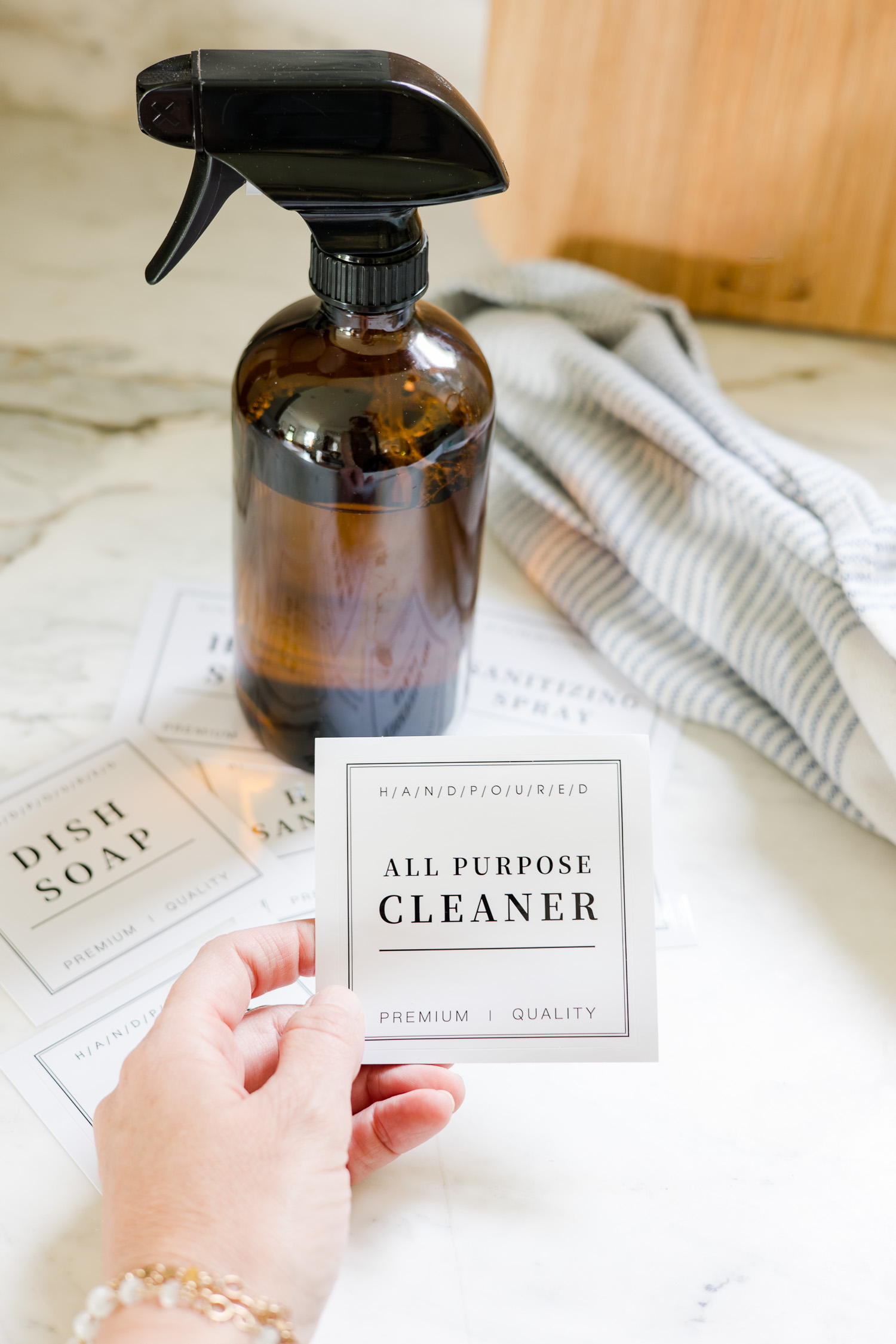 lady holding all purpose cleaner label with amber glass spray bottle