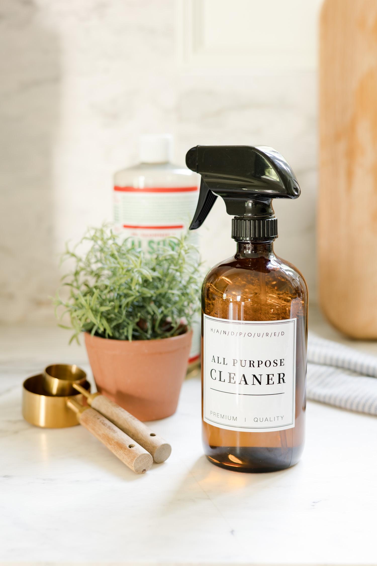 all purpose cleaner in amber glass bottle sitting on countertop next to green plant