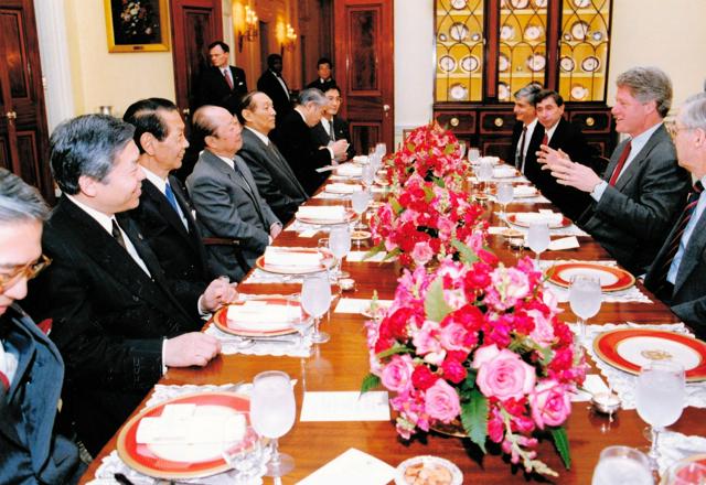 1993年4月、ワシントンのホワイトハウスで開かれた昼食会でクリントン米大統領（右から2人目）と話す宮沢喜一首相（左から4人目）=竹内行夫・元外務事務次官提供