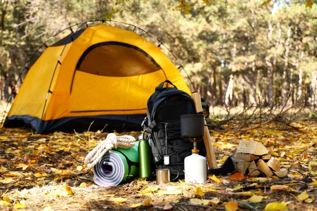 A pop up tent set up in wooded setting.