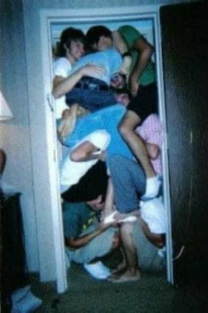 Group of people humorously crammed in a doorway, showcasing a blunder years moment.