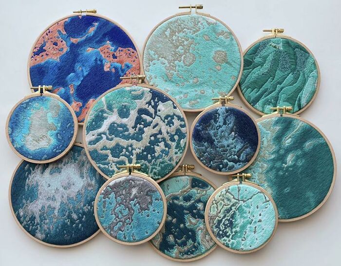 Unique embroidery hoops display artistic ocean designs in various shades of blue and green.