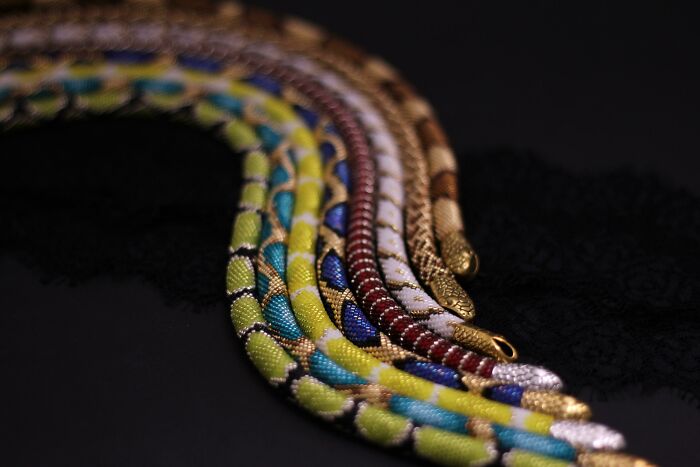 Colorful beaded snake necklaces, part of unique collections on a black background.