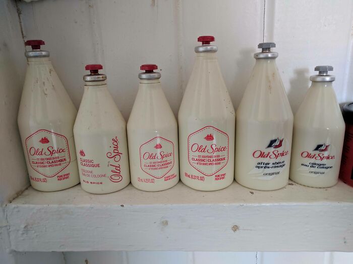 Unique collection of vintage Old Spice cologne bottles on a white shelf.