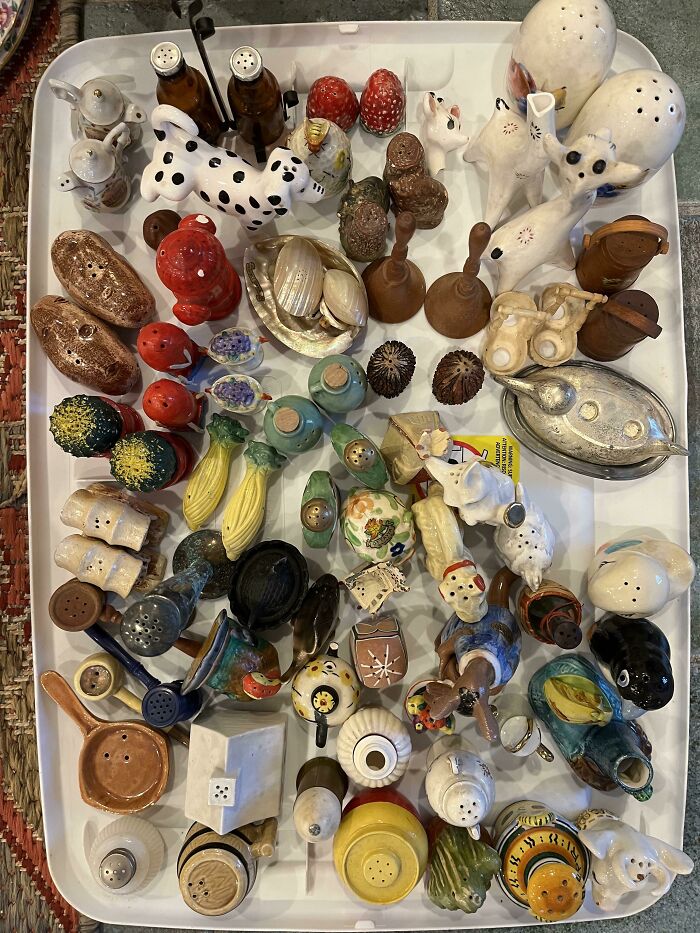 A tray of unexpected unique collections featuring a variety of novelty salt and pepper shakers in different shapes and colors.