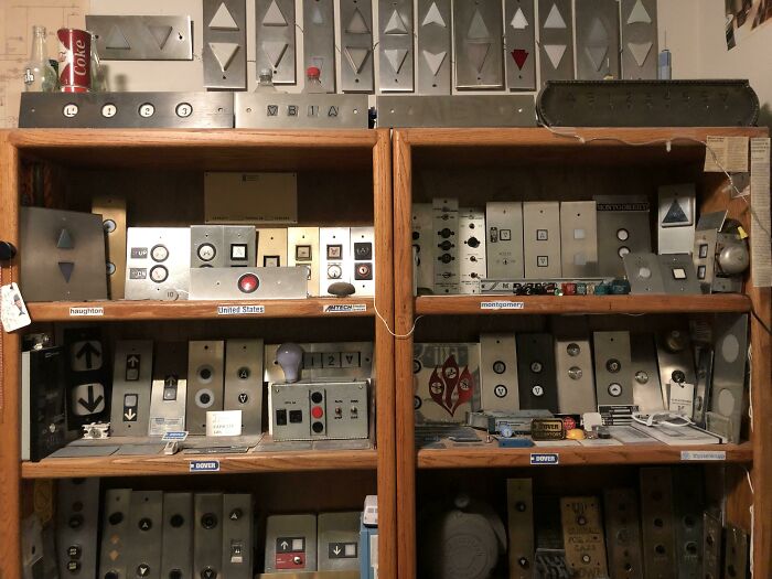 Unique collections of vintage elevator buttons displayed on wooden shelves.