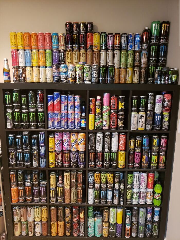 Collection of energy drink cans stacked in a display, showcasing an unexpected unique collection.