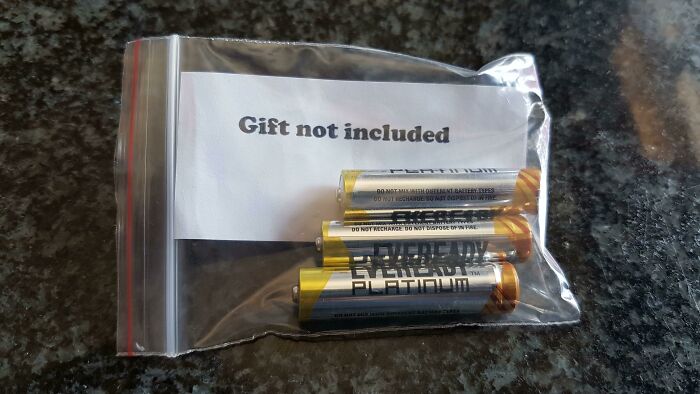 Bag of batteries with a note saying "Gift not included," embodying hilarious trolling Christmas gifts concept.