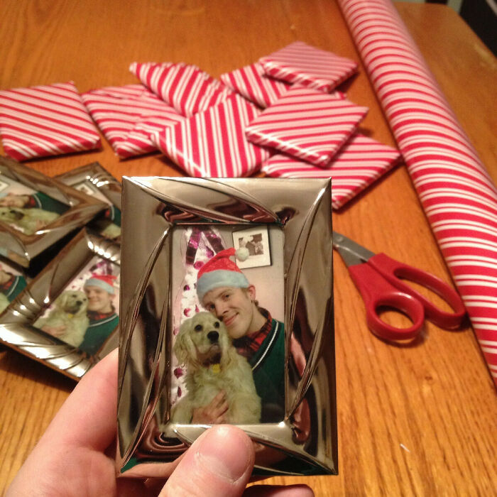 Framed photo of a man in a Santa hat with a dog, surrounded by wrapped presents; a humorous Christmas gift idea.