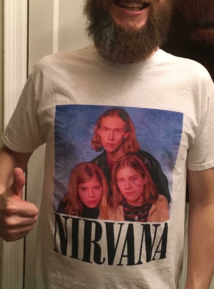 Man wearing a Nirvana shirt with funny photo, giving thumbs up, embodying hilarious trolling Christmas gifts.