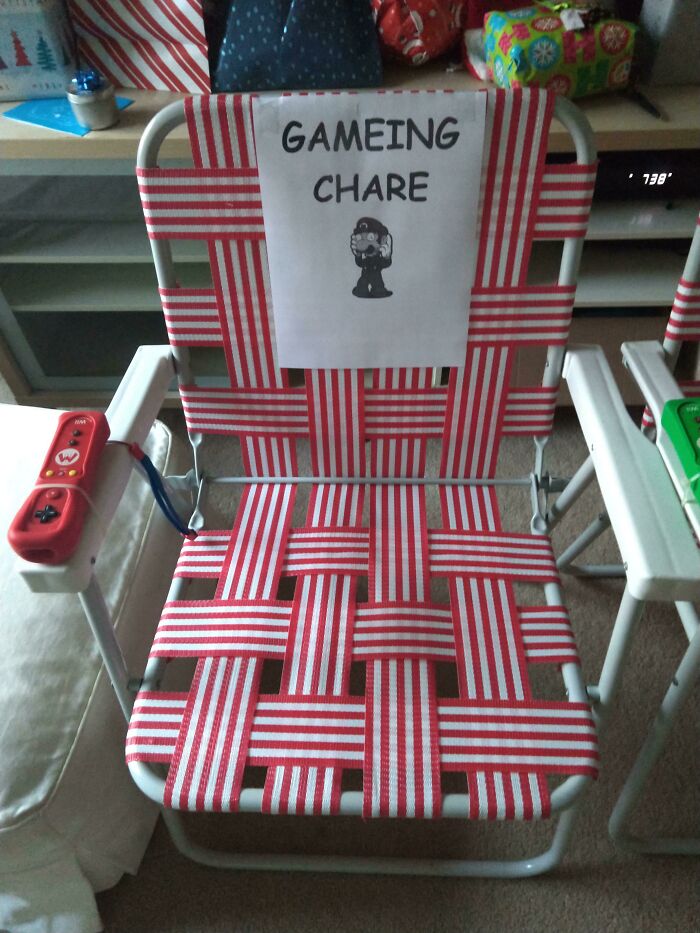 Humorous trolling Christmas gift of a striped chair labeled "gameing chare" with mislabeling and controller taped.