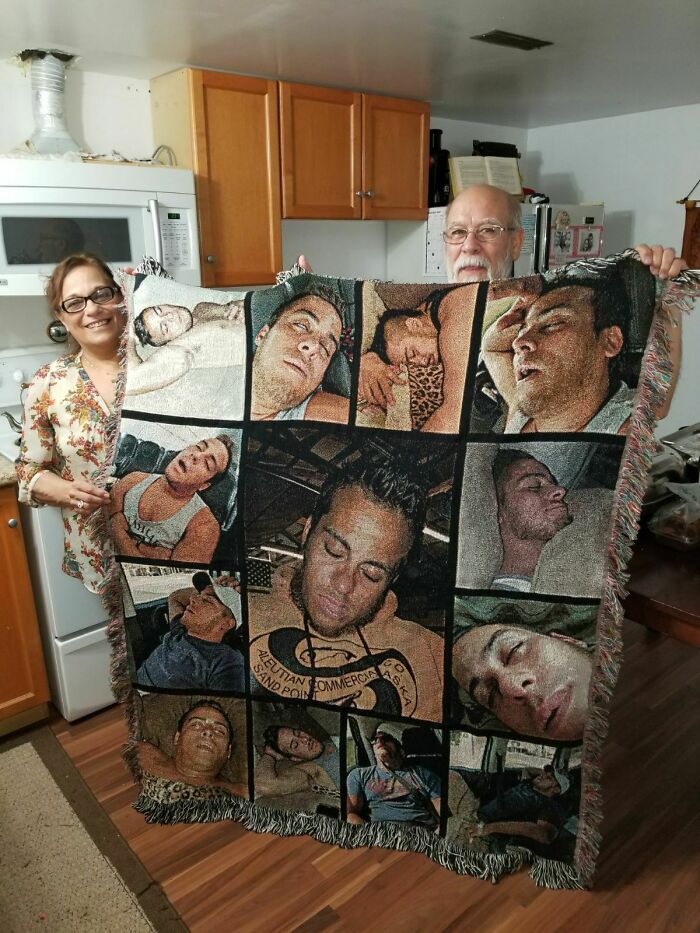 Couple holding a hilarious trolling Christmas gift blanket with funny sleeping photos.