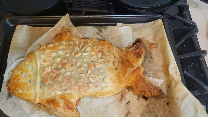 Baked fish-shaped puff pastry on parchment, a creative Christmas snack food idea.