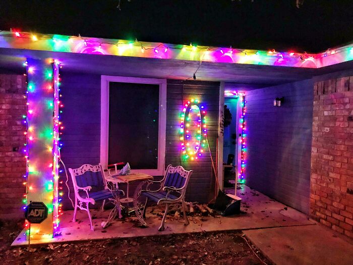 Festive Christmas lights on a porch create a wholesome holiday atmosphere with colorful decorations at night.