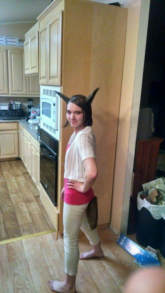 Young girl in a kitchen wearing a homemade animal costume during her blunder years.