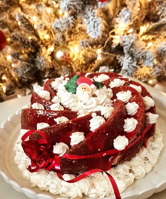 Christmas snack food idea: festive bundt cake with Santa decoration in front of a lit Christmas tree.