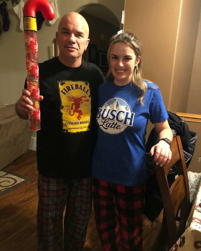 Two people in pajama pants posing with a giant candy cane, embodying hilarious trolling Christmas gifts.