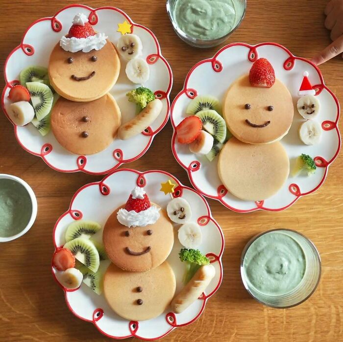 Three festive pancake faces with fruit and Christmas hats, perfect for Christmas snack food ideas.