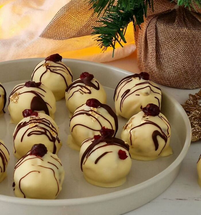 White chocolate truffles with drizzled dark chocolate and dried cranberries, perfect for Christmas snack food ideas.