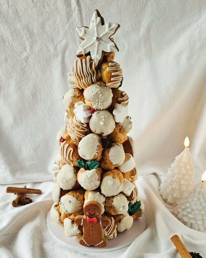 Christmas snack food ideas: edible tree made of pastries, decorated with icing and a gingerbread figure at the base.