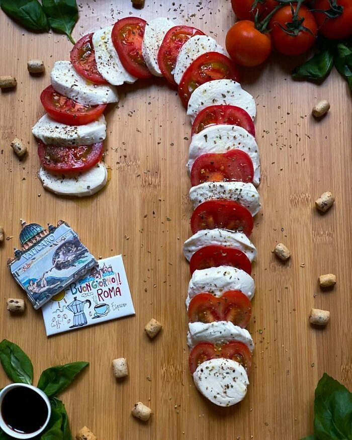 Caprese salad arranged as a candy cane shape, ideal for Christmas snack food ideas.