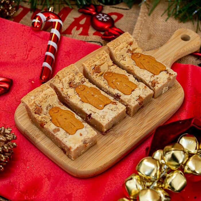 Christmas snack food idea with festive cookie bars on a wooden board, surrounded by holiday decorations.