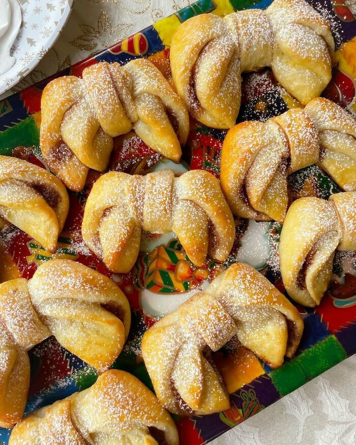 Christmas snack food ideas with sugar-dusted pastries on a festive plate.