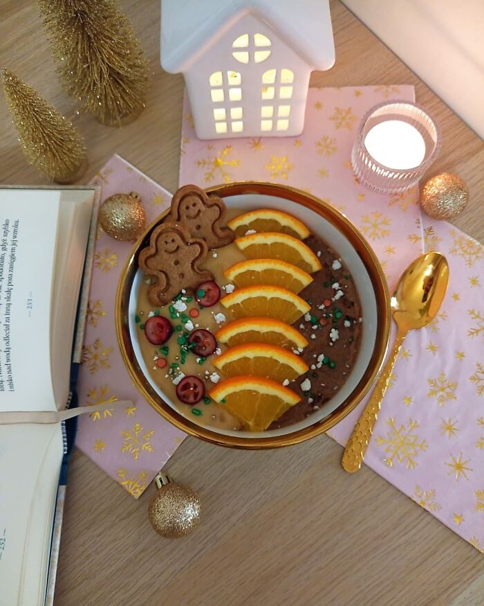 Christmas snack with gingerbread cookies, sliced oranges, and cherries in a decorative bowl on a festive table.