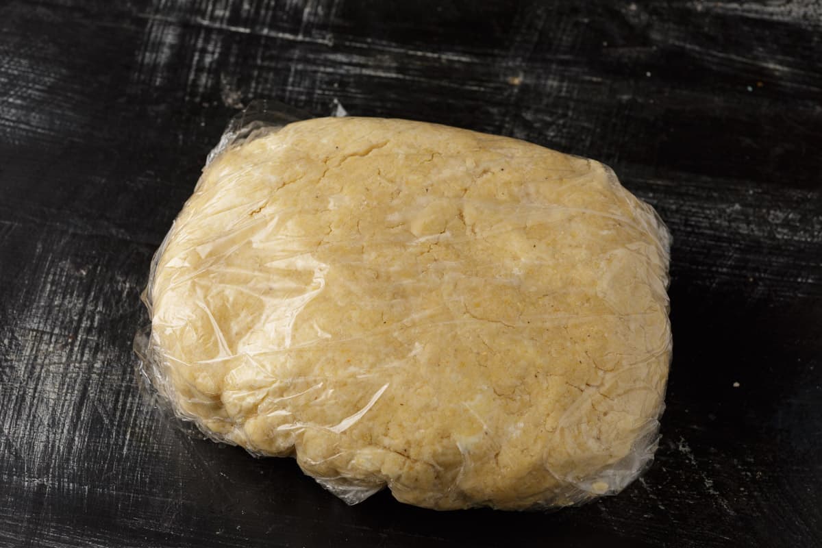 A rectangle of biscuit dough wrapped in plastic wrap