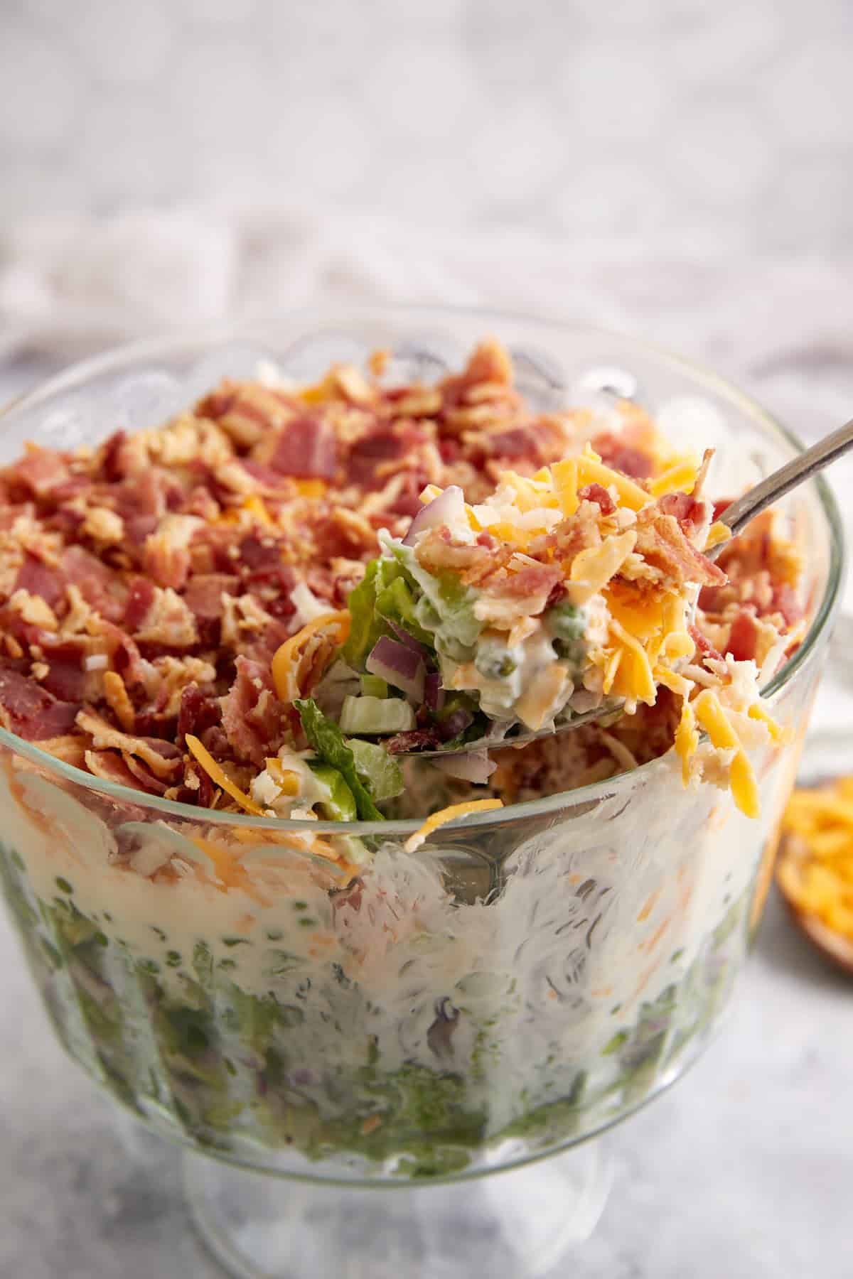 A spoon full of seven layer salad.