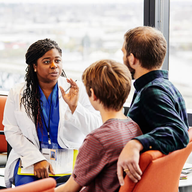 Female medical professional reviewing results with a patient and caregiver.