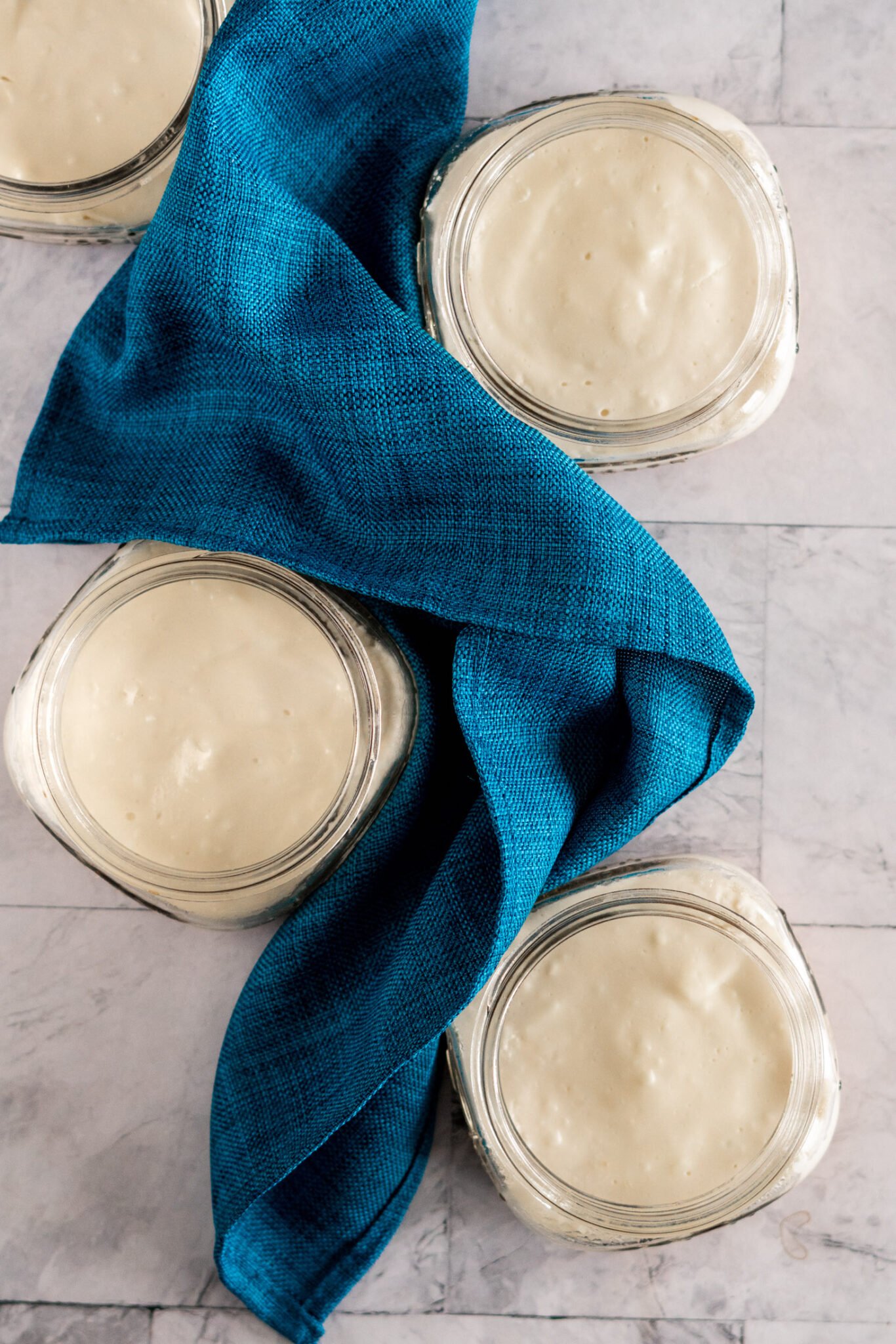 4 sous vide cheesecakes wrapped around a blue napkin.