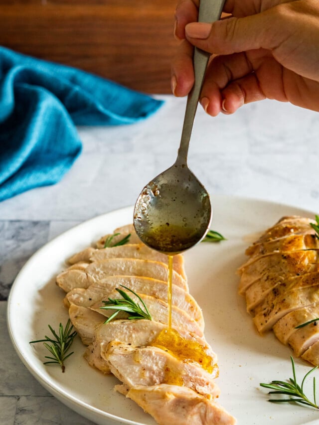 Drizzling poaching butter over the sous vide chicken breast.