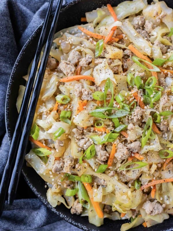 A low-carb egg roll bowl is in a black bowl with green onions.