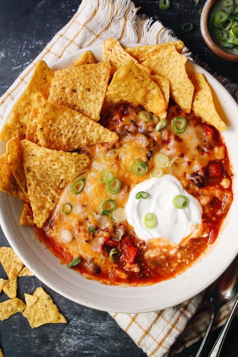 southwest black bean chicken chili topped with cheese, sour cream, green onions and tortilla chips