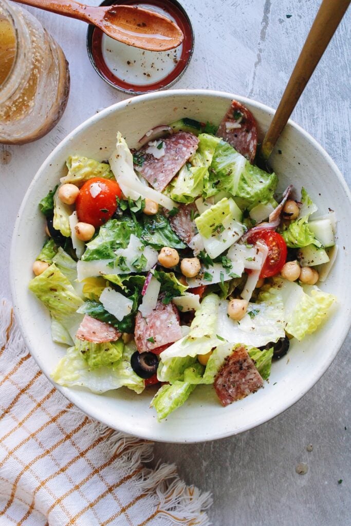 italian chop salad in a white bowl with a plaid napkin on the table