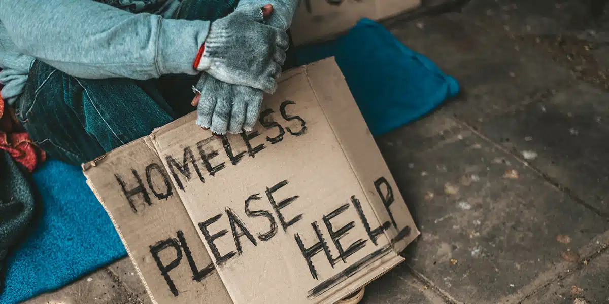 homeless man with a sign, begging for help.