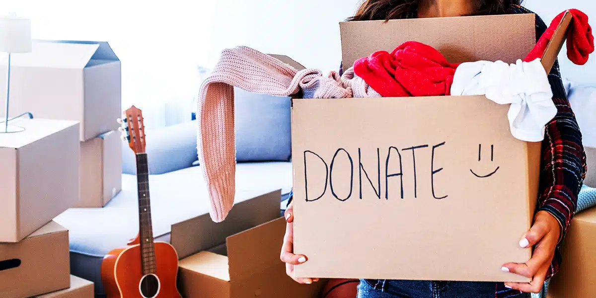 woman filling a box full of stuff ready for donation