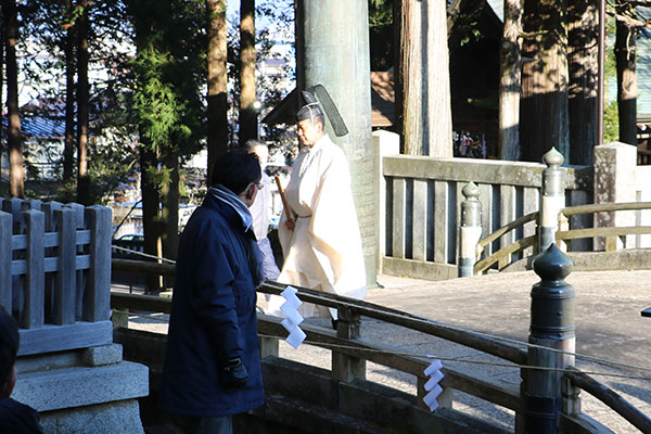 御手洗川に祈る神職