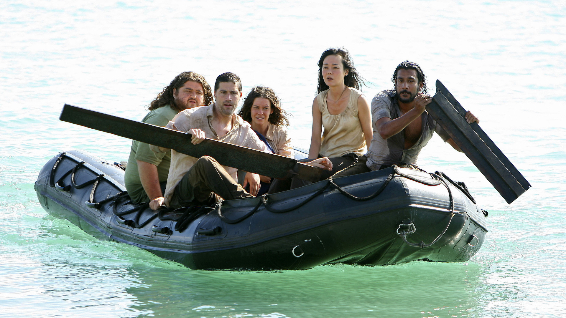 Jorge Garcia, Matthew Fox, Evangeline Lilly, Yunjin Kim, and Naveen Andrews paddling a dingy on the water; still from 'Lost'