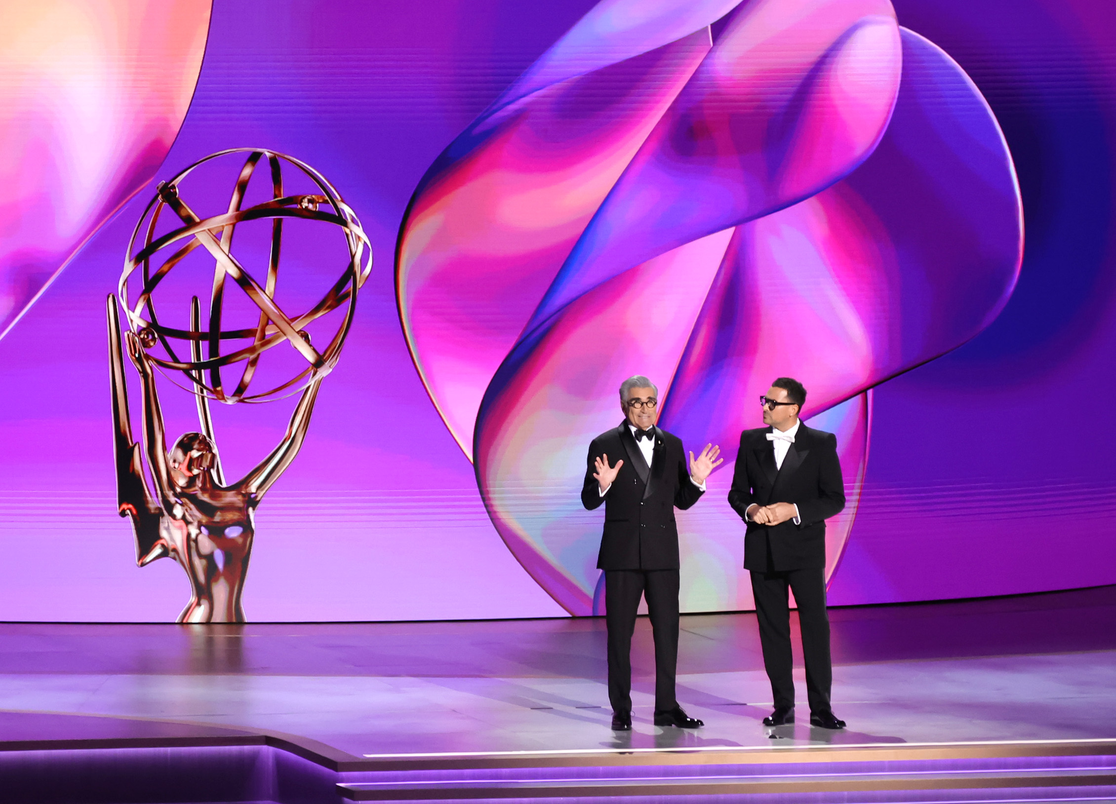 Eugene Levy and Dan Levy speak onstage during the 76th Primetime Emmy Awards