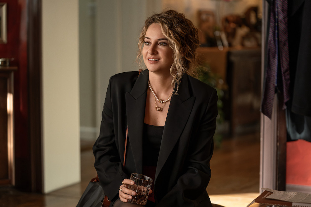 Shailene Woodley in 'Three Women,' a new series where she plays Gia, based on author Lisa Taddeo, shown here sitting with a cocktail, wearing a black suit jacket