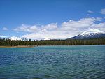 View to the northeast across Lava Lake with three volcanic mountains in the background: South Sister, Broken Top, and Mount Bachelor.