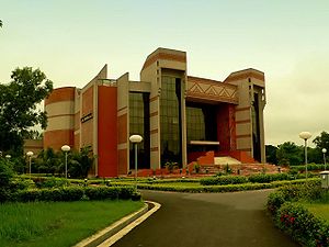 Blocky, red-brick modern building, with landscaped grounds in front