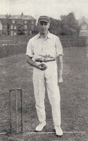 A man in a cricket cap holding a ball