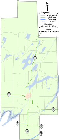 "A map of the entire City of Kawartha Lakes, outlined bya  grey line. The lakes, rivers, and roads of the region are shown. Lakes and rivers are dotted across the region and represented by blue shapes and lines. Kawartha Lakes is shaped like a cross which has been stretched vertically, and is approximately one quarter as wide as it is tall. For identification purposes, the remaining items are described in reference to the horizontal and vertical bar of the cross. Provincial highways, labelled, cross the map in several locations: Highway 35 bisects the entire map, travelling vertically from the bottom-centre to the upper-right along the vertical bar. Highway 7 crosses horizontally just below the mid-point from the left; After crossing Highway 35, it proceeds at an angle to the bottom right corner of the horizontal bar. Highway 7A is a straight and horizontal, bisecting the map below the horizontal arm of the cross. Highway 115, shown as two lines as it is a divided freeway, occupies a small space near the bottom-right corner of the vertical bar, crossing it at a forty-five degree angle up and to the right. The remaining black lines represent the numbered city roads."