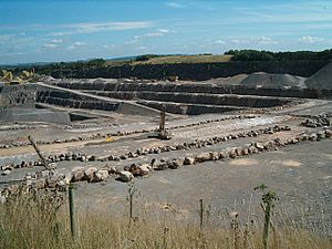 Large expanse of exposed grey rock. Fence in the foreground.