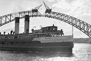 The Dee Why ferry passes the unfinished Sydney Harbour Bridge