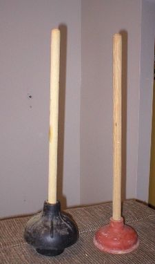 2 upright plungers, left one black with extension, right one red.